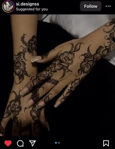 two hands with henna tattoos on them