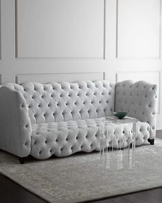 a white couch sitting on top of a rug