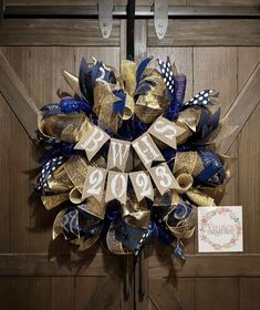 a blue and gold new year's wreath hanging on the front door to celebrate