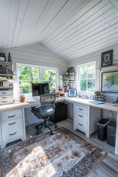 a home office with lots of storage space and white walls, along with an area rug on the floor