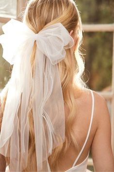 the back of a woman's head wearing a white veil with long hair in it