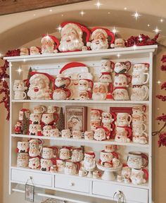 a shelf filled with santa claus mugs and christmas decorations