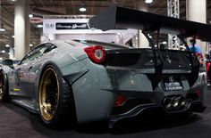 the rear end of a silver sports car on display