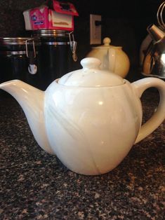 a white tea pot sitting on top of a counter