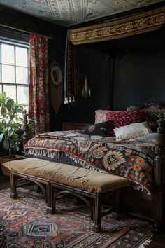 a large bed sitting next to a window covered in curtains and pillows on top of a rug