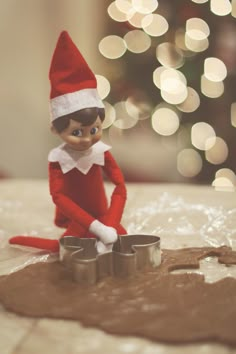 an elf is sitting on top of a cookie sheet