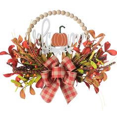 a wreath with a bow on it that says fall and is decorated with leaves, berries, and a pumpkin