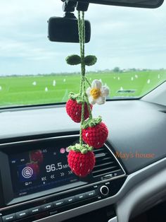 two strawberries hanging from the dashboard of a car