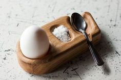 an egg and spoon on a wooden tray