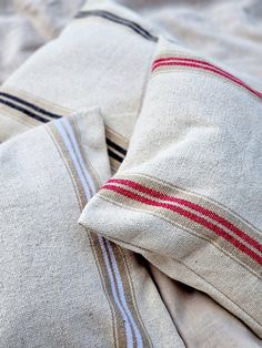 two pillows on top of each other with red, white and blue striped linens