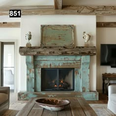 a living room with a fire place in the center and a tv on top of it