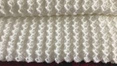 two white crocheted blankets sitting next to each other