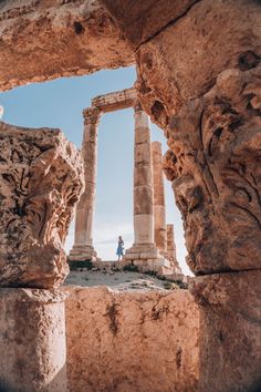 a person standing in between two stone pillars