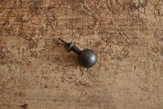 a wooden table with a metal knob on it's end and nails sticking out of the wood