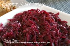 a white plate topped with red cabbage next to bread