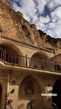 an old building with balconys and balconies in front of a rocky cliff