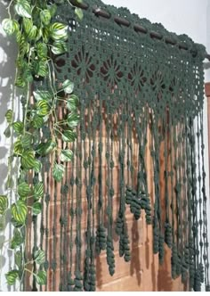 a green crocheted curtain hanging from a wall