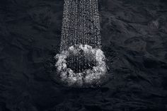 a shower head in the middle of water with bubbles coming from it's sides