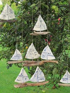 a wind chime with sailboats hanging from it's sides on a tree branch