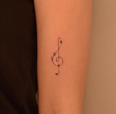 a small musical note tattoo on the arm