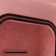 a bathroom with pink tiles and black trim