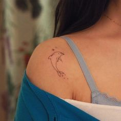 a woman with a dolphin tattoo on her shoulder