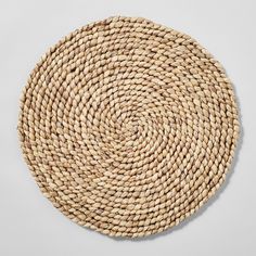 a round woven placemat on a white surface with the center circle made out of straw