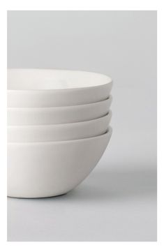 four white bowls stacked on top of each other