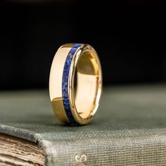 a close up of a ring on top of a book with a blue stone in it