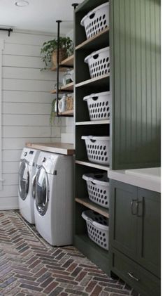 a washer and dryer in a laundry room with green cabinets, shelving