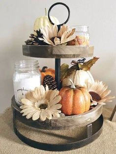 three tiered tray with pumpkins, flowers and candles