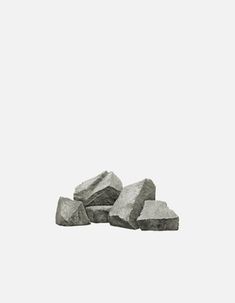 some rocks are sitting on the ground in front of a white background and one is black and white