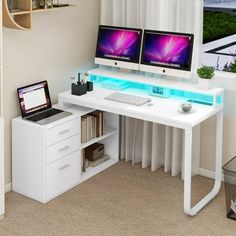 two computer monitors sitting on top of a white desk