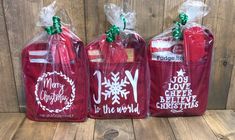 three red bags with white lettering on them sitting on a wooden table next to each other