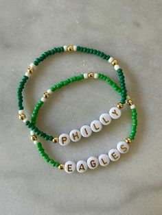 - Calling all Philly football fans! Personalize your custom eagles bracelet for game day. Choose from seed bead with 18k gold accents or a full gold beaded beaded with green accents. Gold filled beads are much more tarnish resistant and long lasting, opposed the the more commonly seen gold plated. These bracelets layer well with others so add this to your stack for your next tailgate! Beaded on high quality stretch cord and secured. - Listing is for (1) bracelet or set of (2). Set includes (1) gold beaded bracelet with green accent and (1) seed bead bracelet.  Choice of kelly green or dark green. -  4mm 18k gold filled beads       3mm glass seed beads     acrylic letter beads      -  Enter your own customization and color choice in personalization box. Feel free to message me with any ques Personalized Beaded Bracelets For Game Day, Team Spirit Beaded Bracelets For Game Day, Personalized School Spirit Jewelry For Game Day, School Spirit Personalized Jewelry For Game Day, Team Spirit Round Beads Jewelry For Game Day, Customizable Team Spirit Jewelry For Game Day, Game Day Bracelets With Letter And Round Beads, Philly Football, Eagles Gear