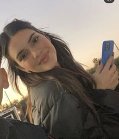 a man and woman taking a selfie with their cell phones