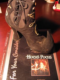 an old pair of shoes sitting on top of a book with the words hocus pocus written on it