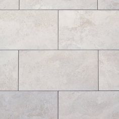 a white tile wall with grey grouting