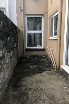 the back side of a house with a window and hoses in front of it