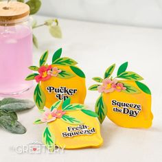 three pieces of fruit shaped soap sitting on top of a table next to a bottle