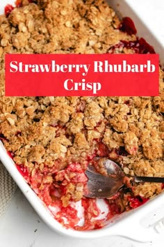 strawberry rhubarb crisp in a white baking dish with a red sign over it that says, strawberry rhubarb crisp