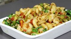 a white bowl filled with macaroni salad on top of a gray countertop