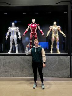 a man standing in front of a display of iron man costumes