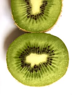 two kiwi slices cut in half sitting on top of each other next to each other