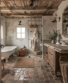 an old fashioned bathroom with stone flooring and exposed wood ceiling, along with a white tub