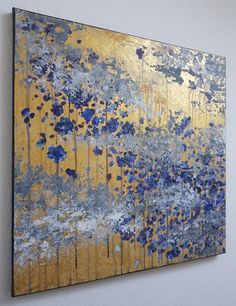 an abstract painting with blue and yellow flowers on the bottom half of it, against a white wall