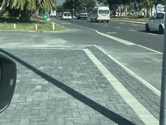 cars are driving down the street near palm trees