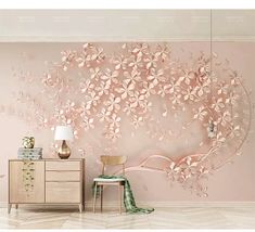 a pink wall with flowers on it and a chair