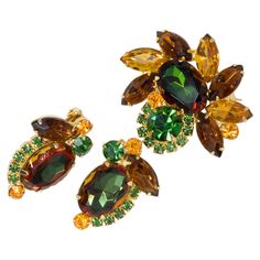 An exquisite brooch/pin and a pair of clip-on earrings by Juliana DeLizza & Elster. A single watermelon crystal is prong set and accented with smaller chatons and navettes in amber, green, yellow, and orange colors. Pin: 4.3cm x 3.9cm Earrings: 3.3cm x 1.9cm Glamorous Jewelry, A Group Of People, Group Of People, Crystal Brooch, New Leaf, Melon, Clip On, Prong Setting, Fall Colors