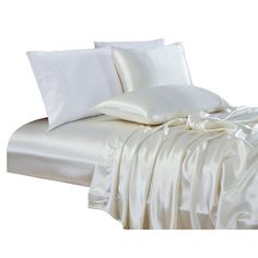 a bed with white sheets and pillows on it